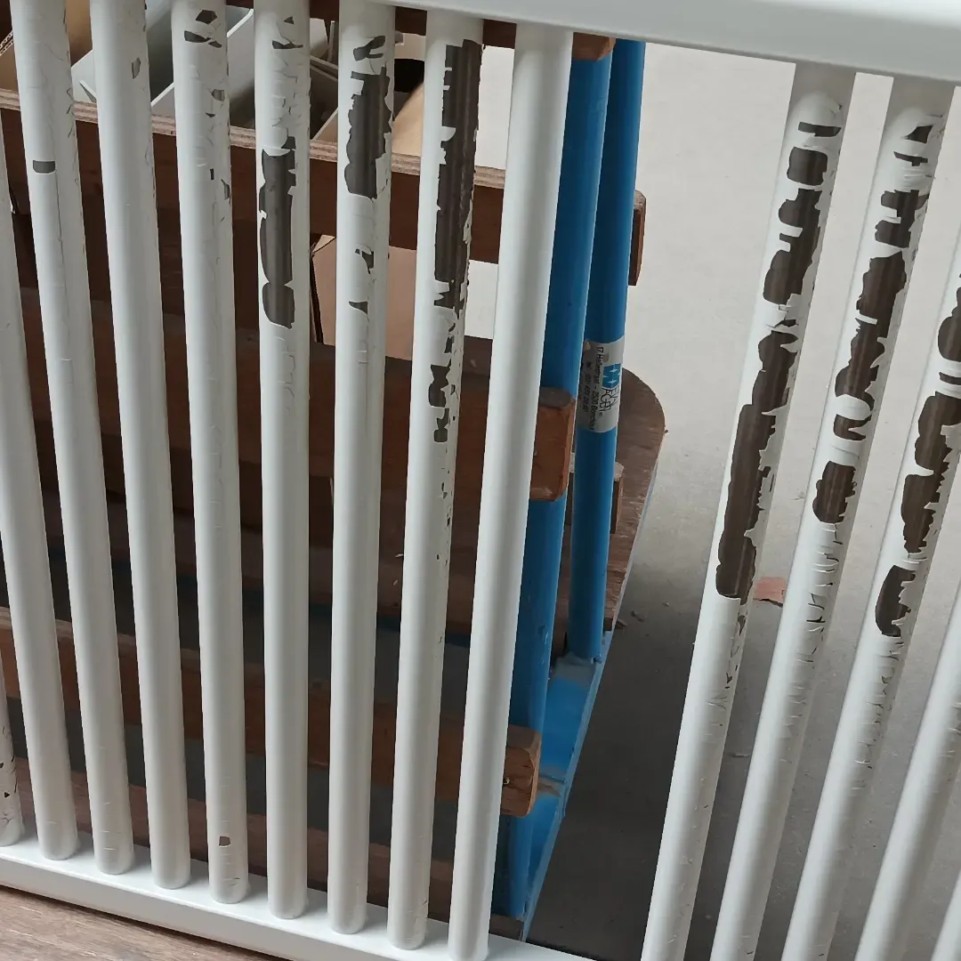 Kolomradiator met sterk afbladderende oude lak, vóór het stralen