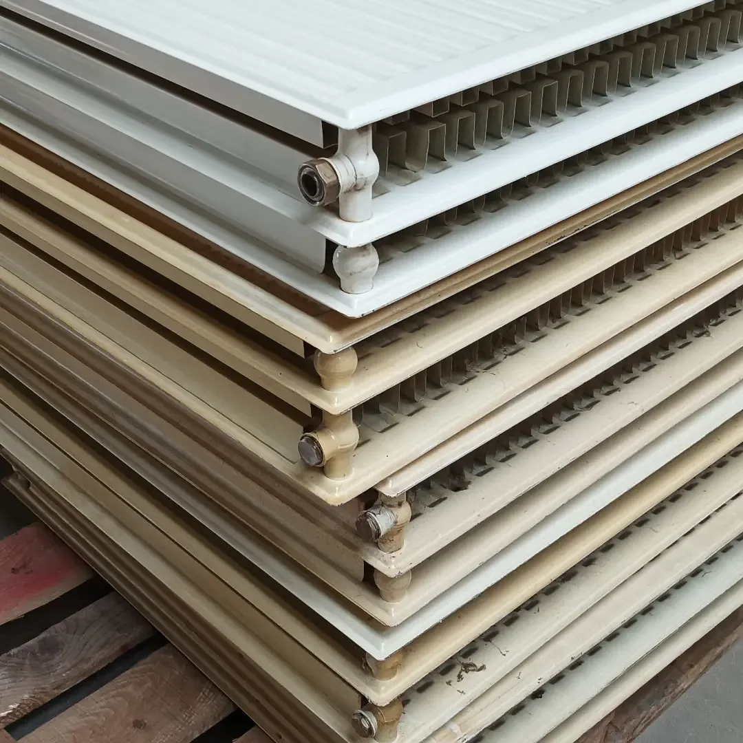 Stapel vergeelde crèmekleurige paneelradiatoren vóór de renovatie