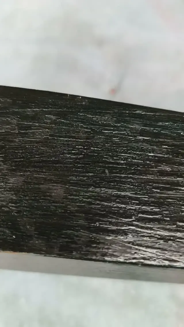 Houten plank met oude zwarte lak die wordt verwijderd, met turquoise lak eronder
